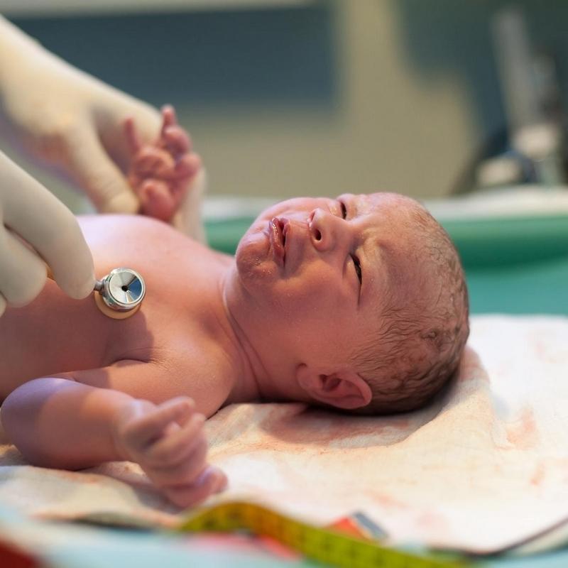 Newborn baby being checked by doctor